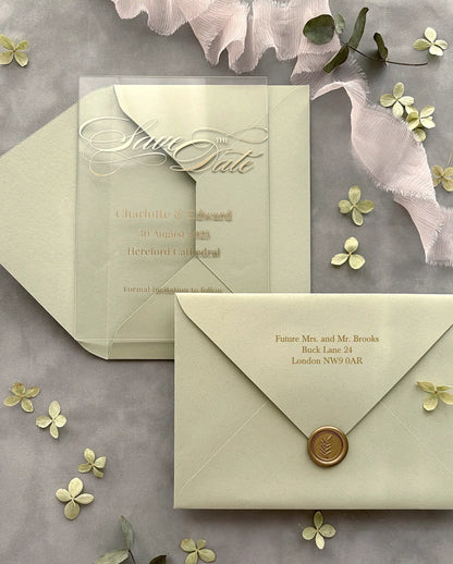Acrylic Save the Date card with gold foil names and white script lettering, sage green envelope with gold foil guest addressing and gold wax seal — Polina Perri