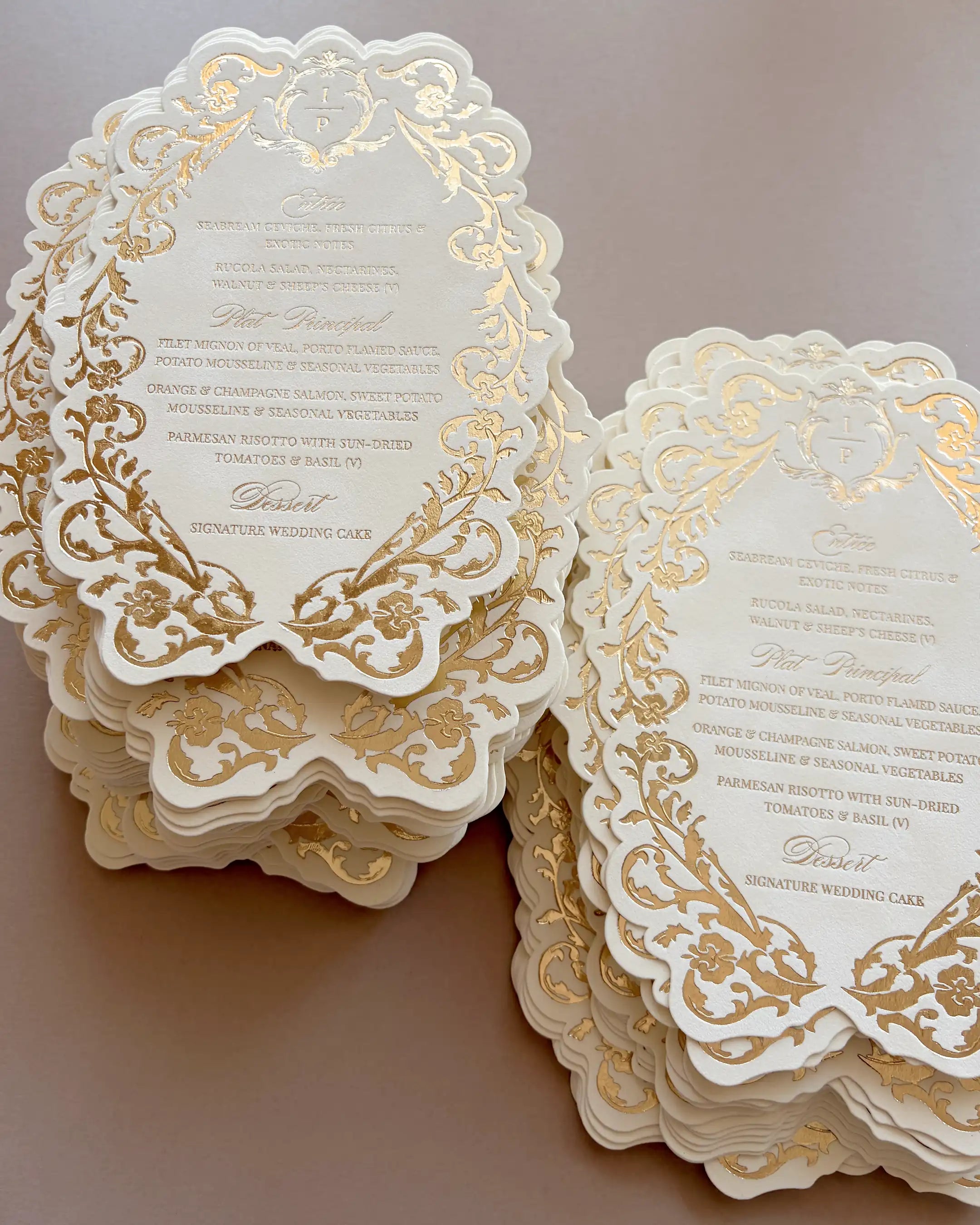 Belle wedding menu with gold foil-pressed floral border and scalloped edge, two stacked sets on a neutral background | Polina Perri