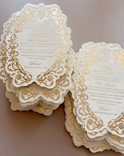 Belle wedding menu with gold foil-pressed floral border and scalloped edge, two stacked sets on a neutral background | Polina Perri