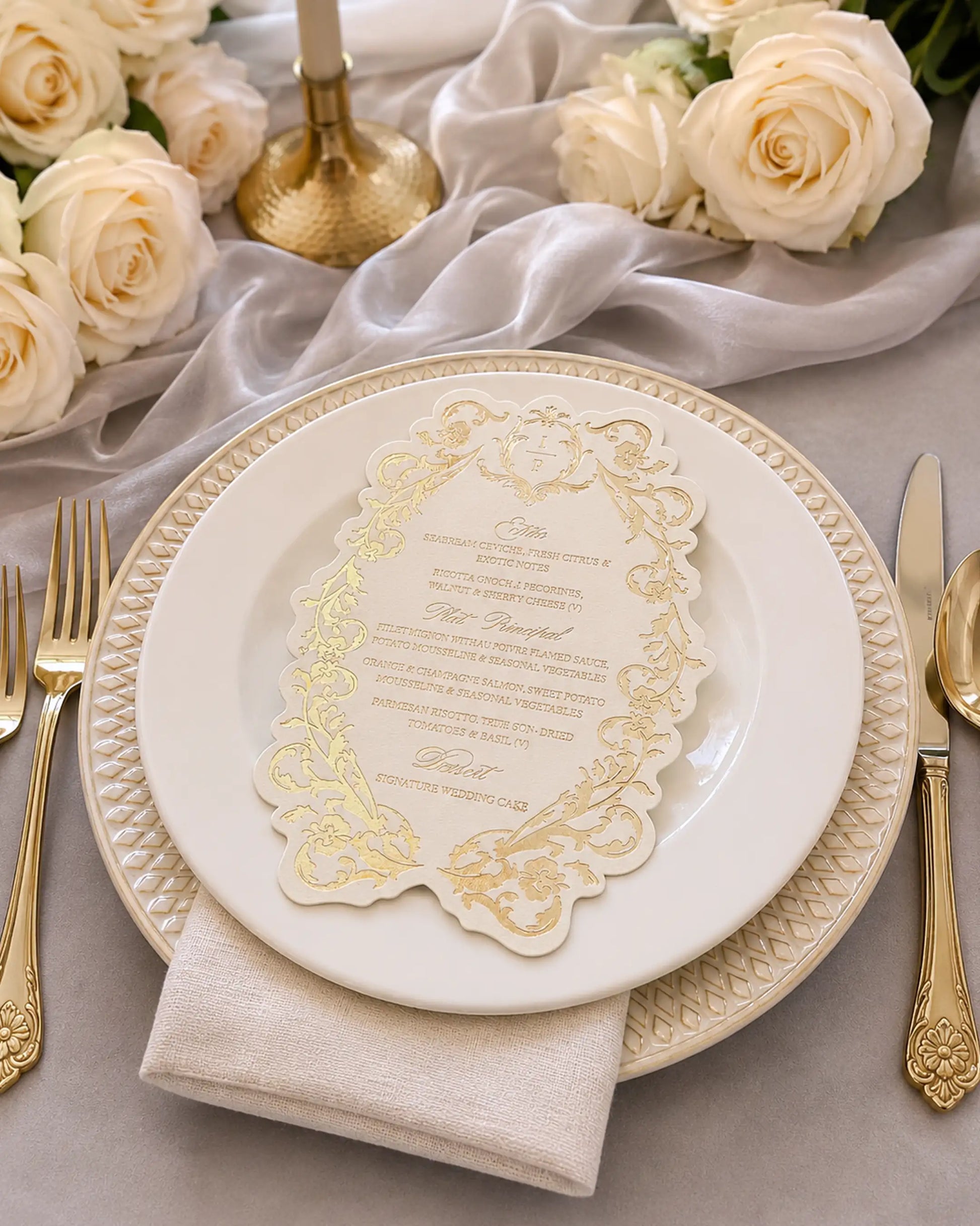 Belle wedding menu with gold foil-pressed floral border on a place setting with charger plate, linen napkin, gold flatware and cream roses | Polina Perri